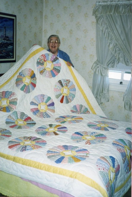 1999_0900_Mother L_holding up white quilt w circles